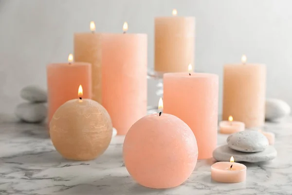 Composição de velas ardentes e pedras de spa na mesa. Espaço para texto — Fotografia de Stock