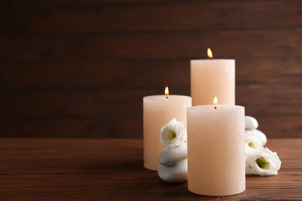 Состав горящих свечей, спа-камней и цветов на столе. Пространство для текста — стоковое фото