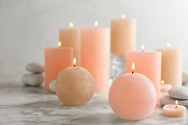 Composição de velas ardentes e pedras de spa na mesa. Espaço para texto — Fotografia de Stock