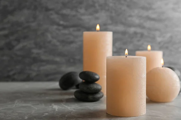 Hořící svíčky a lázeňské kameny na stole. Místo pro text — Stock fotografie
