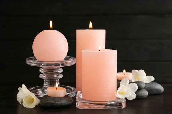 Σύνθεση της καύσης κεριά, πέτρες σπα και λουλούδια στο τραπέζι — Φωτογραφία Αρχείου