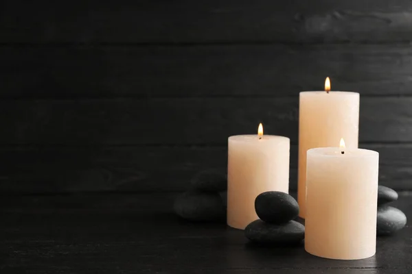 Brennende Kerzen und Wellness-Steine auf dem Tisch. Raum für Text — Stockfoto