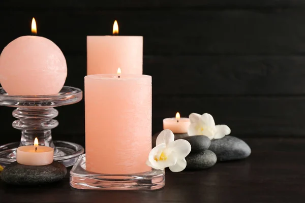 Skład płonących świec, kamieni spa i kwiatów na stole. Miejsce na tekst — Zdjęcie stockowe