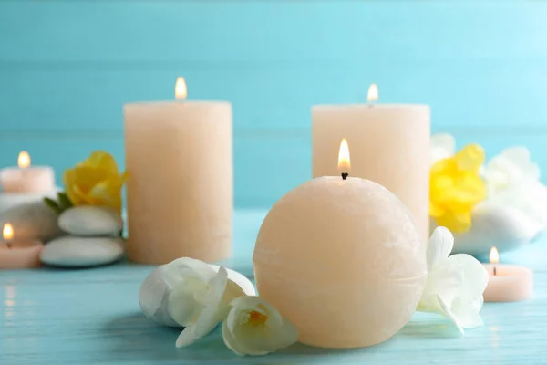 Brennende Kerzen, Wellness-Steine und Blumen auf dem Tisch. Raum für Text — Stockfoto