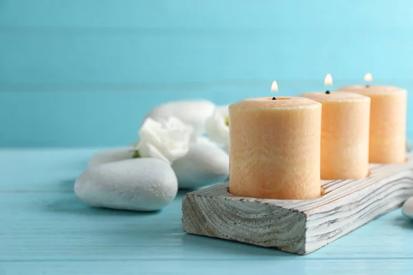 Komposition mit brennenden Kerzen, Wellness-Steinen und Blumen auf dem Tisch. Raum für Text — Stockfoto