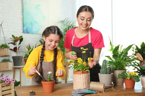 Mor och dotter tar hand om krukväxter hemma — Stockfoto