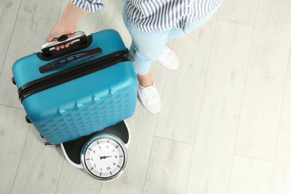 Woman weighing suitcase indoors, top view. Space for text — Stock Photo, Image