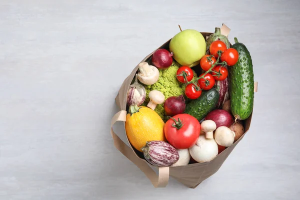纸袋里装满了新鲜蔬菜，背景轻盈，顶视。文本空间 — 图库照片