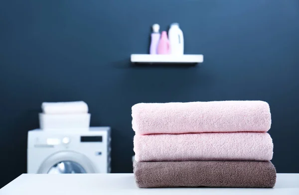 Clean towels and detergent in the laundry against blue wall. Stock Photo by  Nadianb