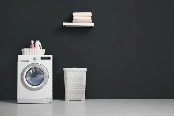 Moderní pračka, koš na prádlo a police s ručníky v koupelně. Místo pro text — Stock fotografie