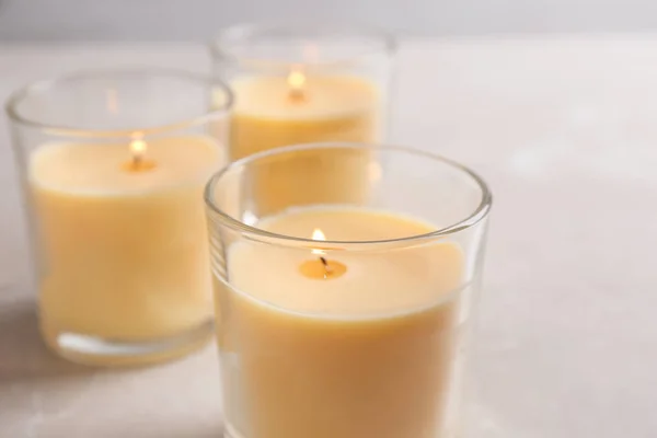 Tres velas encendidas en vasos sobre la mesa —  Fotos de Stock