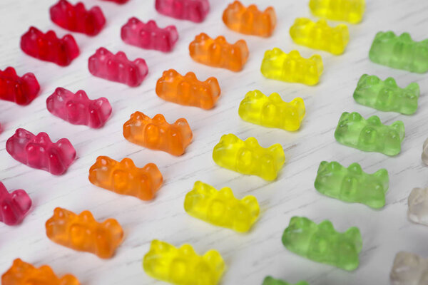 Delicious color jelly bears on white wooden table