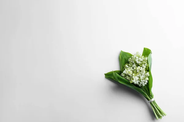 Beautiful lily of the valley bouquet on white background, top view. Space for text — Zdjęcie stockowe