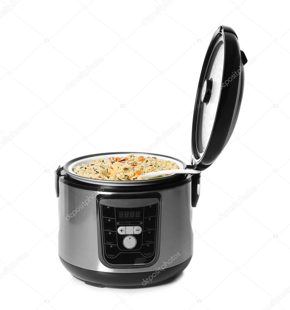 Delicious rice with vegetables and spoon in modern multi cooker on white background