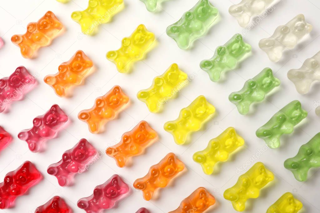 Many delicious little jelly bears on white background, top view