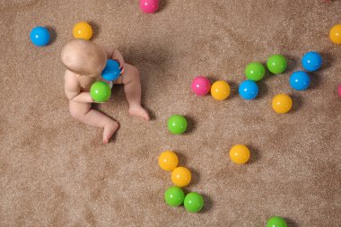 Oyuncaklar, üst görünüm ile halı üzerinde sürünen sevimli küçük bebek