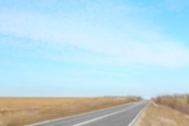 Mavi gökyüzü ve asfalt yolun bulanık görünümü