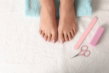 Beyaz havlu, metin için alan güzel ayakları ve pedikür aksesuarları ile kadın üst görünümü. Spa tedavisi