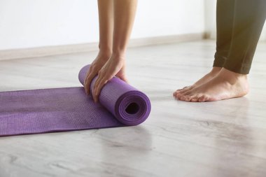 Yoga mat katta kapalı, closeup haddeleme kadın