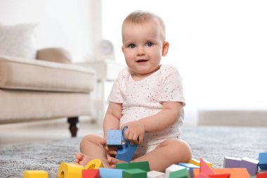 Sevimli kız bebek odada yapı taşları ile oynarken
