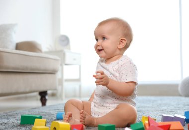 Sevimli kız bebek odada yapı taşları ile oynarken