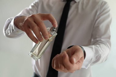 Kapalı mekanlarda bileküzerine parfüm uygulayan adam, yakın çekim