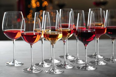 Bulanık arka plana karşı masada farklı şaraplar olan bir gözlük grubu