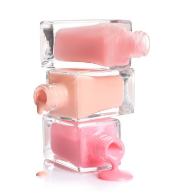 Beyaz arka plan üzerinde şişe ile dökülen farklı ojeler