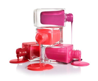 Beyaz arka plan üzerinde şişe ile dökülen farklı ojeler