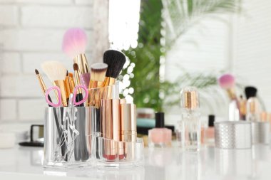 Ayna ile tuvalet masası üzerinde lüks makyaj ürünleri ve aksesuarları. Metin için alan