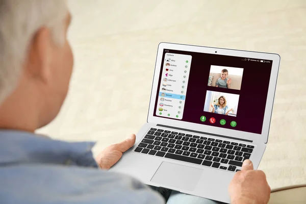 Крупним планом вид на старшого чоловіка, який розмовляє з членами сім'ї через відео чат вдома — стокове фото