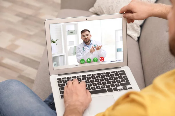 Homem usando laptop para consulta on-line com médico via chat de vídeo em casa, close-up — Fotografia de Stock
