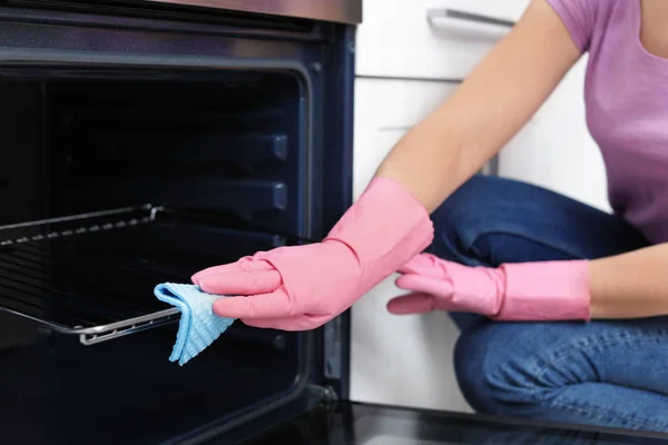 Estante del horno de limpieza de mujer con trapo en la cocina, primer plano —  Fotos de Stock