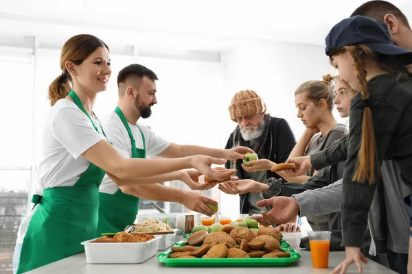 Pobres que reciben comida de voluntarios en el interior — Foto de Stock