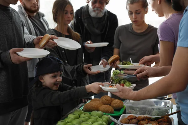 Pobres que reciben comida de voluntarios en el interior — Foto de Stock