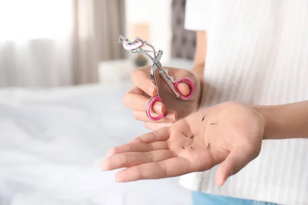 Frau mit Lockenwickler und heruntergefallenen Wimpern drinnen, Nahaufnahme der Hände. Raum für Text — Stockfoto