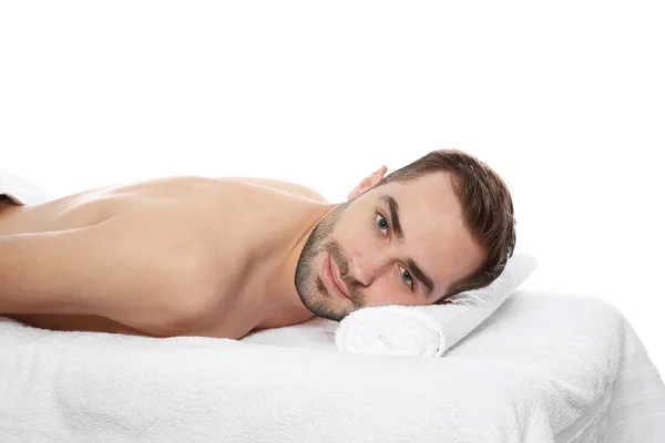 Hombre guapo relajándose en la mesa de masaje sobre fondo blanco. Servicio de spa —  Fotos de Stock