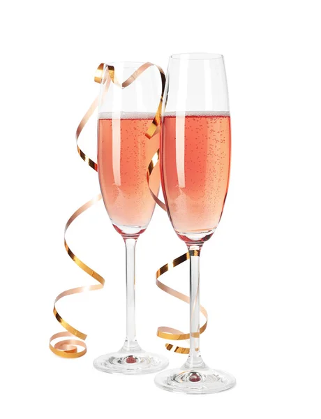 白に隔離された金のストリーマーとバラのシャンパンのグラス — ストック写真