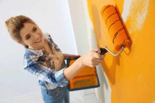 Mujer feliz pintando la pared interior, por encima de la vista. Reparación casera — Foto de Stock