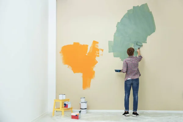 Jeune homme peignant mur à l'intérieur, espace pour le texte. Réparation de maison — Photo