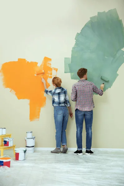 Pareja joven pintando la pared interior. Reparación casera — Foto de Stock