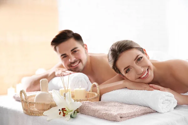 Young couple with spa essentials in wellness center — Stock Photo, Image