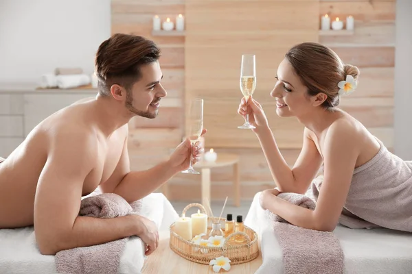 Romantic young couple with champagne in spa salon — Stock Photo, Image