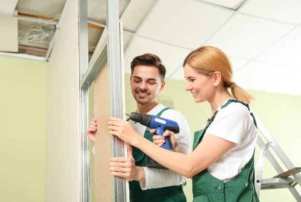Workers installing drywall indoors. Home repair service — 스톡 사진