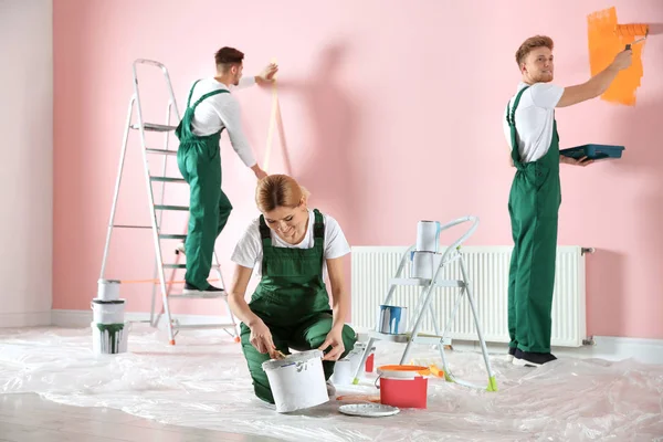 Equipe de decoradores profissionais pintura parede dentro de casa. Serviço de reparação em casa — Fotografia de Stock