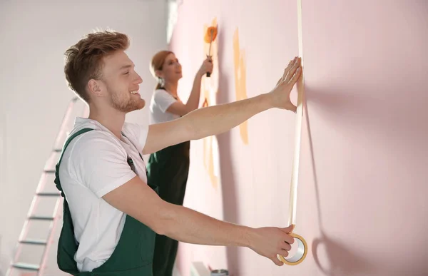 Decoradores profesionales pintando paredes en interiores. Servicio de reparación en el hogar — Foto de Stock