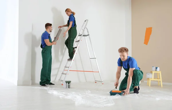 Decoradores profesionales trabajando en interiores. Servicio de reparación en el hogar — Foto de Stock