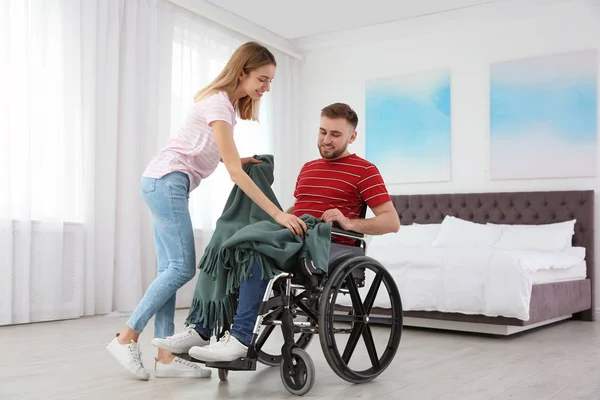 Kobieta na wózku inwalidzkim z kratą w domu. Pomoc osobom niepełnosprawnym — Zdjęcie stockowe