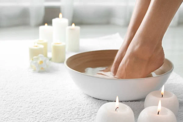 Woman soaking her feet in dish indoors, closeup with space for text. Spa treatment — Stock Photo, Image