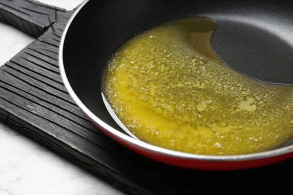 Сковородка с плавильным маслом на столе, крупный план — стоковое фото